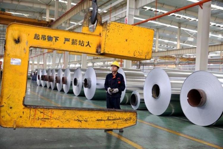 图:安徽一工厂内,工人正在装卸铝锭  法新社